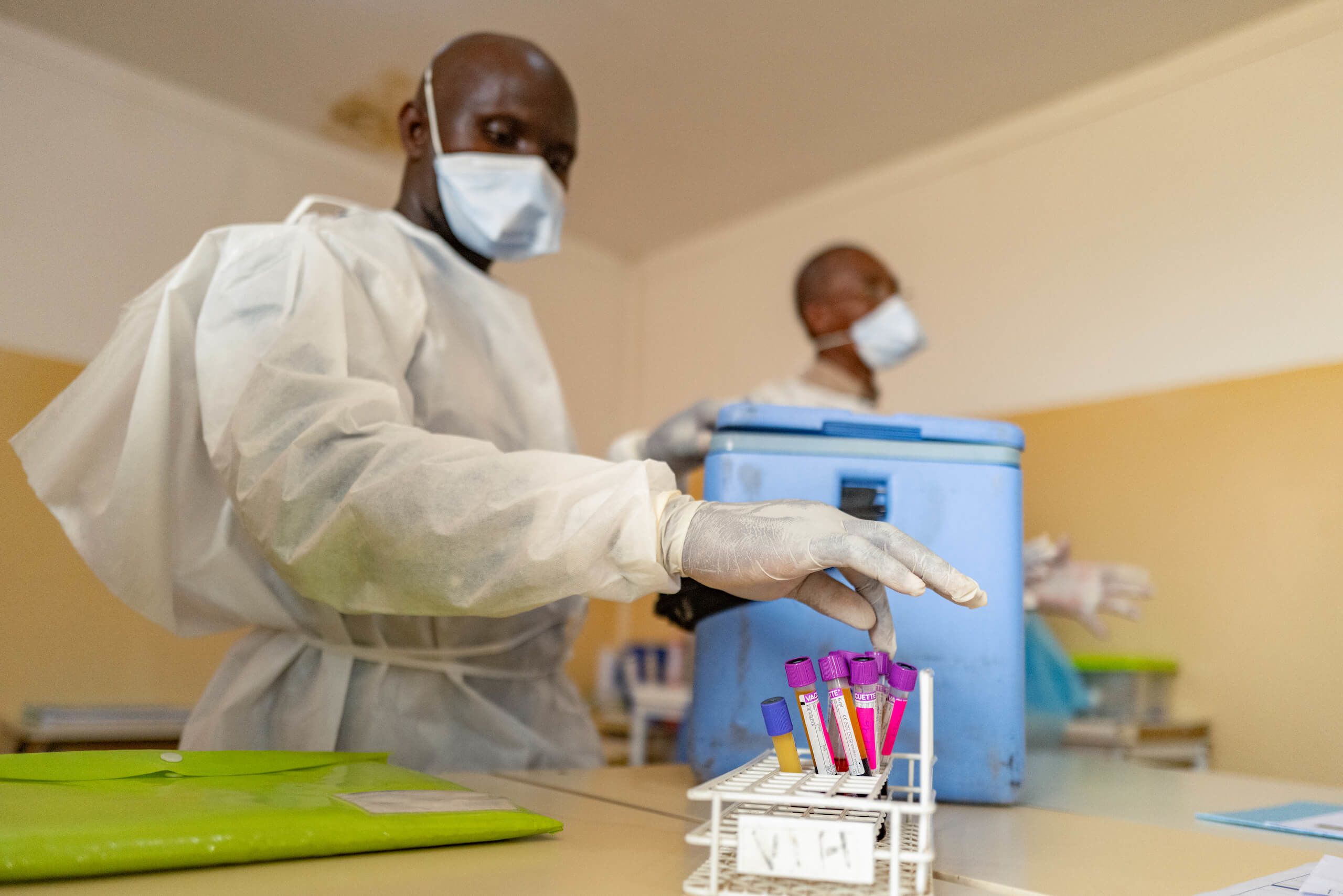 Abdoulaye Baldé (foreground), assistant driver, and Alficene Kandé, a driver, downloading an ice box with suspected patient samples